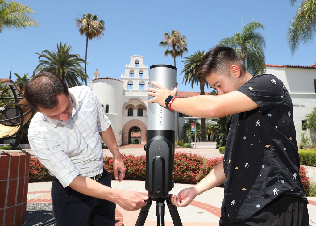 Tom Esposito (left) and Thomas Tran (right) set up the Unistellar telescope in front of Hepner Hall